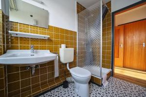 a bathroom with a toilet and a sink at Appartement-5 in Süddorf