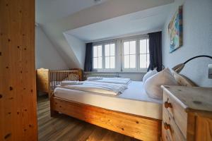 a bedroom with a wooden bed with a window at Appartement-5 in Süddorf