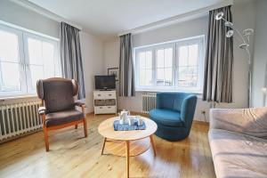a living room with a couch and two chairs and a table at Appartement-9 in Süddorf