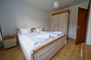 a bedroom with a large white bed with white sheets at Appartement-9 in Süddorf
