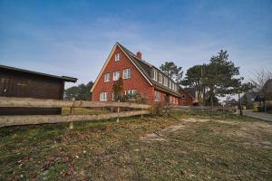 a red brick house with a fence in front of it at Appartement-9 in Süddorf