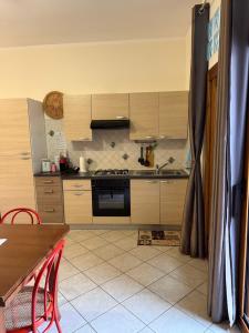 a kitchen with wooden cabinets and a table with red chairs at Luciana House in Olbia +8 photos