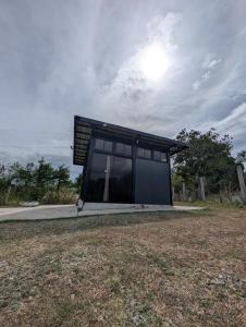 a small house with a black roof on a field at The G Residence in Calatagan