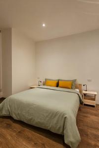 a bedroom with a large bed with two yellow pillows at CA' VARADE di Martina Scarduelli in Varallo