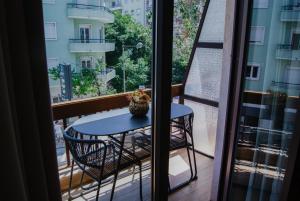 a table and chair on a balcony with a window at Dom João Glamour Hotel in Lisbon