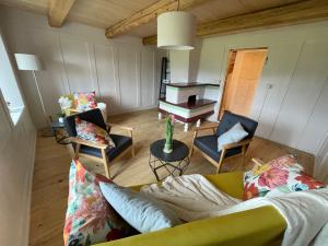 a living room with a couch and chairs and a piano at Stöckli Gantrisch-Blick in Rüeggisberg