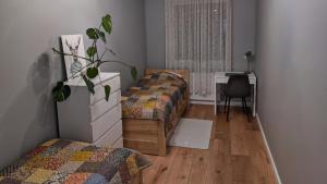 a bedroom with two beds and a desk and a table at Apartament Honoratka in Jelenia Góra +24 photos