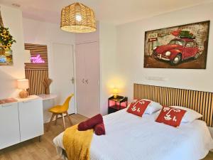 a bedroom with a bed with a red car on the wall at ''Coccinelle'' WIFI - CENTRE - MODERNE in Dax