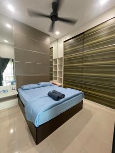 a bedroom with a bed with a ceiling fan at Afiq's Homestay, Manjung in Seri Manjung