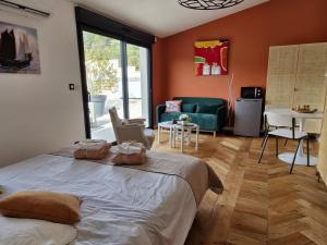 a bedroom with a bed and a living room at Le cottage Bleu du Sud in Saint-Étienne-les-Orgues