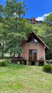 a small house with a bench in a field at Cabana na Mata Paraíso da Serra in Aquidauana