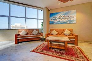 a living room with two couches and a table at FabHotel Pearl Inn in Pune