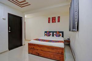 a bedroom with a bed and a black door at FabHotel Pearl Inn in Pune