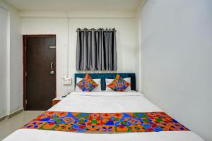 a bedroom with a bed with a colorful blanket on it at FabHotel Pearl Inn in Pune