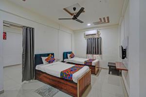 a bedroom with two beds and a ceiling fan at FabHotel Pearl Inn in Pune