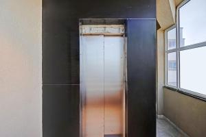 a glass door in a room with two windows at FabHotel Pearl Inn in Pune +21 photos