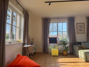 a living room with a couch and a window at Villa Oni met grote speelruimte in Koksijde