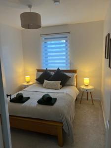 a bedroom with a bed with two lamps and a window at 60 Springfield Road in Stornoway