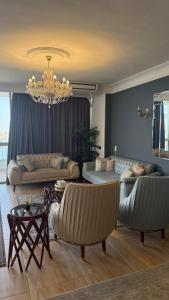 a living room with two couches and a chandelier at Apartment on the Nile, 3 bedrooms and a living room in Cairo