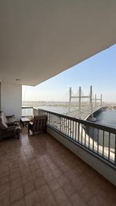 a large balcony with a view of a bridge at Apartment on the Nile, 3 bedrooms and a living room in Cairo