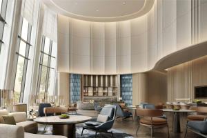 a lobby with tables and chairs and a large chandelier at Courtyard by Marriott Yibin in Yibin