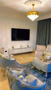 a living room with chairs and a flat screen tv at Apartment on the Nile, 3 bedrooms and a living room in Cairo