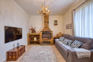 a living room with a couch and a fireplace at Stunning 2BR Villa with Pool in Mġarr