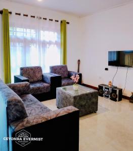 a living room with couches and a coffee table at Ceyonra Evermist Residence in Nuwara Eliya