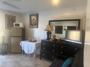 a room with a dresser with a table and a mirror at My Help Comes from The Lord Miami in Palmetto Bay