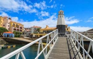 a lighthouse on a boardwalk in front of a city at My Help Comes from The Lord Miami in Palmetto Bay