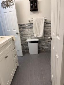 a bathroom with a toilet and a towel at My Help Comes from The Lord Miami in Palmetto Bay
