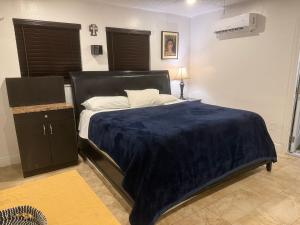 a bedroom with a bed with a blue blanket on it at My Help Comes from The Lord Miami in Palmetto Bay