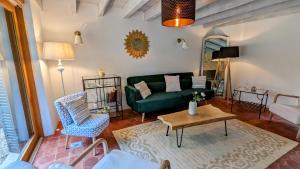 a living room with a green couch and a table at Au fil du temps in Santenay