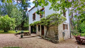 an exterior view of a stone house with a picnic table at Au fil du temps in Santenay