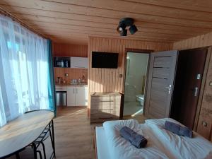 a room with two beds and a table and a kitchen at Felągówka in Murzasichle
