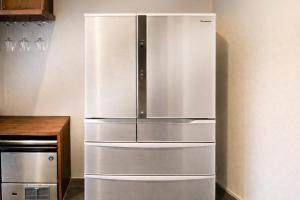 a large stainless steel refrigerator in a kitchen at The Lake House 野尻湖 in Shinano