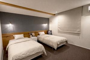 a bedroom with two beds and a window at The Lake House 野尻湖 in Shinano +33 photos