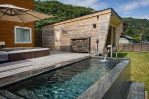 a backyard with a pool and a house with a fireplace at The Lake House 野尻湖 in Shinano