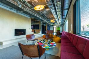 a room with a red couch and chairs and a table at Domeq FREE Parking, Gym, Co-working and Terrace in Komárov