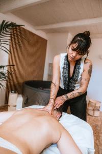 a woman sitting on a bed getting a massage at Palazzo Sisina in Rutigliano