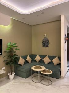 a living room with a green couch and a table at Sky High Nest Noida in Ghaziabad