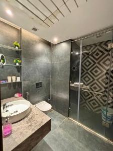 a bathroom with a shower and a sink and a toilet at Sky High Nest Noida in Ghaziabad +30 photos