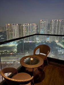 a balcony with two chairs and a table and a city at Sky High Nest Noida in Ghaziabad