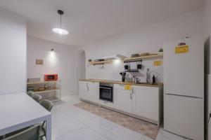 a kitchen with white cabinets and a refrigerator at A Casa Gualandi in Bologna