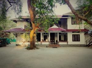 a house with a tree in front of it at Marari Jose Villas in Mararikulam +5 photos