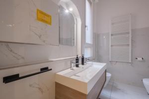 a white bathroom with a sink and a mirror at A Casa Gualandi in Bologna +59 photos