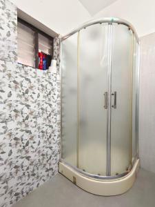 a shower with a glass door in a bathroom at Marari Jose Villas in Mararikulam