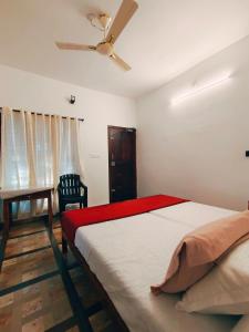 a bedroom with a bed and a ceiling fan at Marari Jose Villas in Mararikulam
