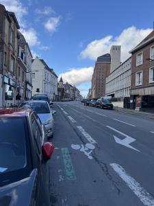 a street with cars parked on the side of the road at Cityscape in Arras