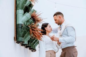 a bride and groom drinking wine in front of a wall at Palazzo Sisina in Rutigliano